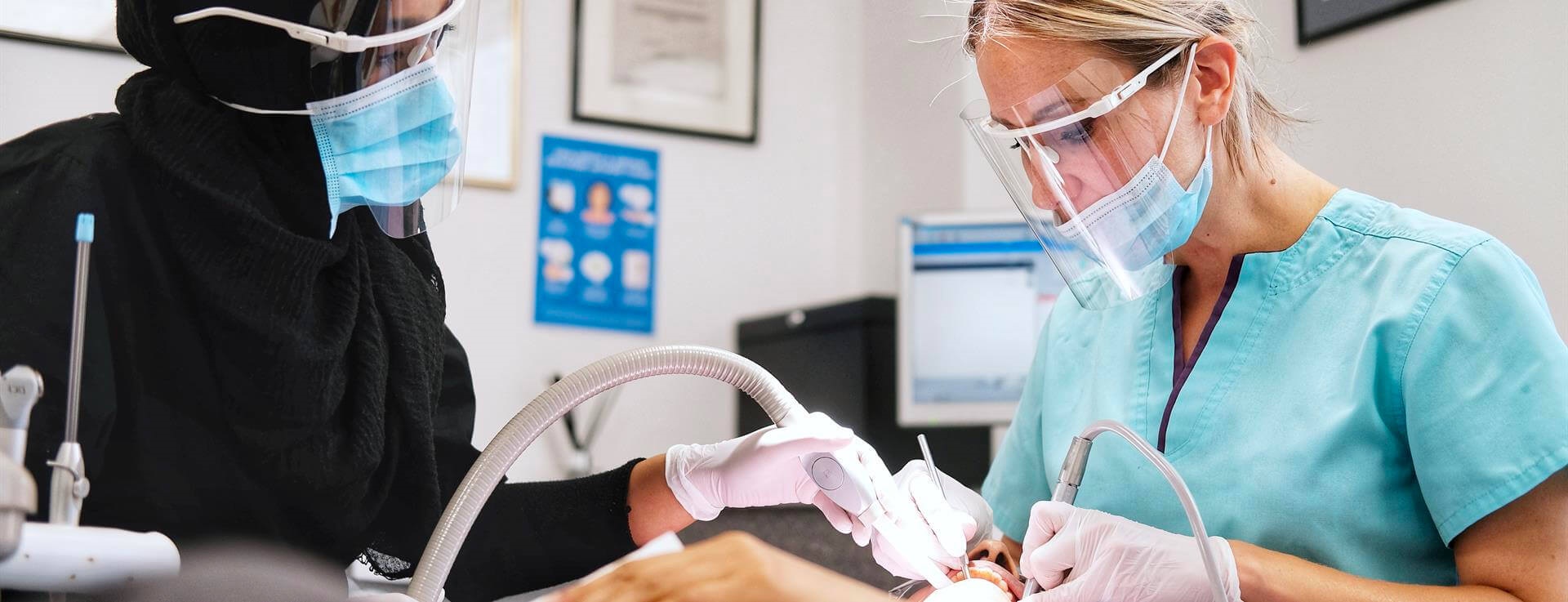 Two dentists treating patient